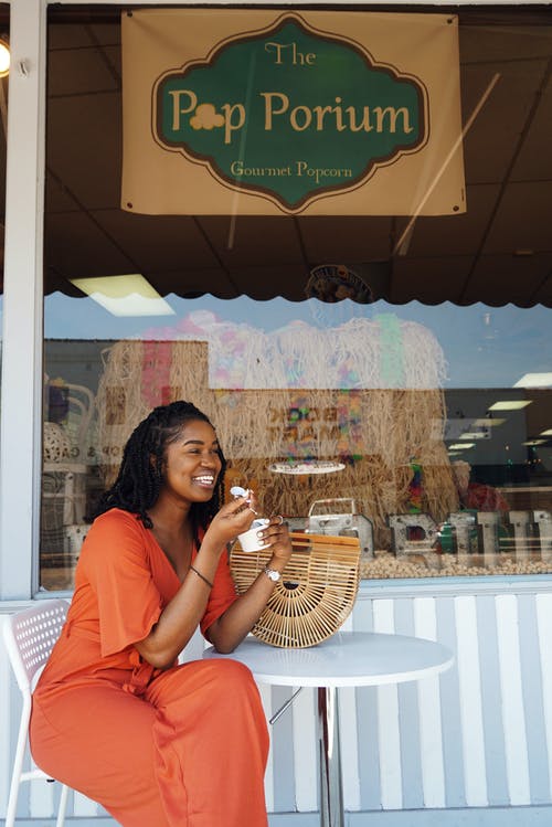女人微笑着和吃流行por店外 · 免费素材图片