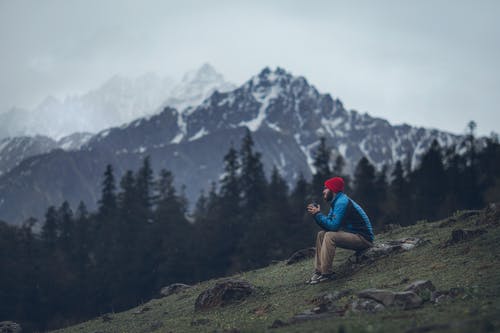 男子坐在岩石上的照片 · 免费素材图片