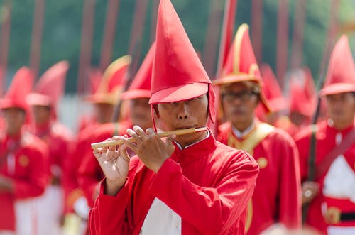 戴红色帽子和制服演奏长笛的人 · 免费素材图片