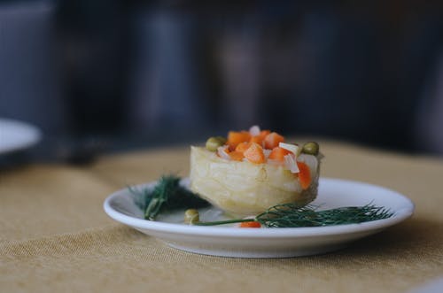 煮熟的豌豆，胡萝卜和迷迭香叶在白板上的照片 · 免费素材图片