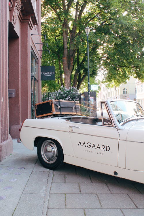 白色敞篷跑车的侧视图照片停在建筑物外面 · 免费素材图片