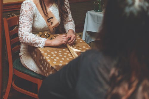 女人坐在椅子上，拿着礼物 · 免费素材图片