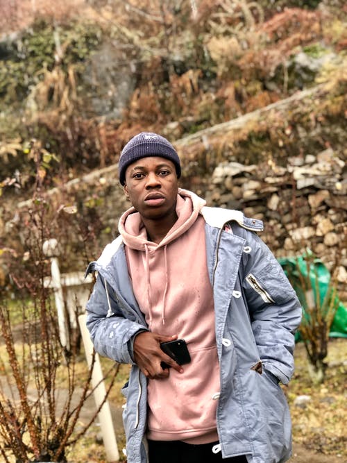 拿着电话的重夹克的人 · 免费素材图片