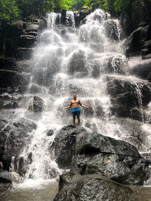 裸照的男人站在一块岩石上级联的中心 · 免费素材图片