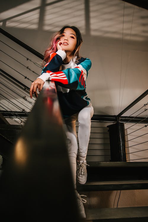 女人坐在钢栏杆上 · 免费素材图片