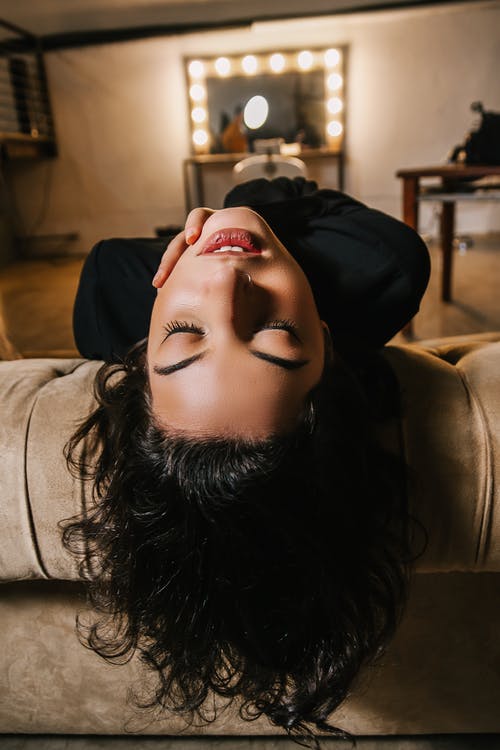 向后倾斜她的头在沙发上，她的眼睛的女人的特写照片 · 免费素材图片