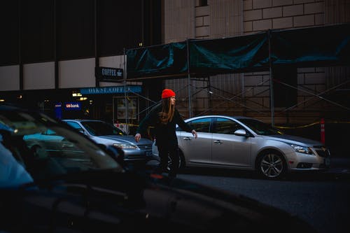 黑夹克的妇女有红色帽子的在街道滑冰 · 免费素材图片