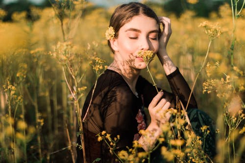 女人闻黄色花的照片 · 免费素材图片