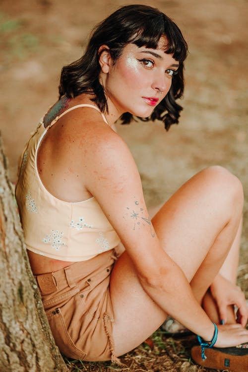 靠在一棵树上坐着一个女人的照片 · 免费素材图片