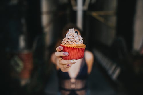 女人拿着蛋糕的选择性焦点摄影 · 免费素材图片