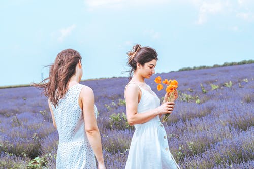 两个女人站在花场的照片 · 免费素材图片
