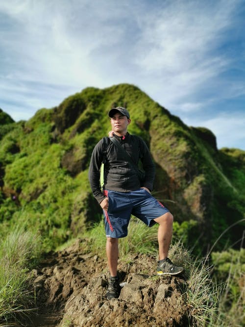身穿黑色运动衫站在悬崖上的男人 · 免费素材图片