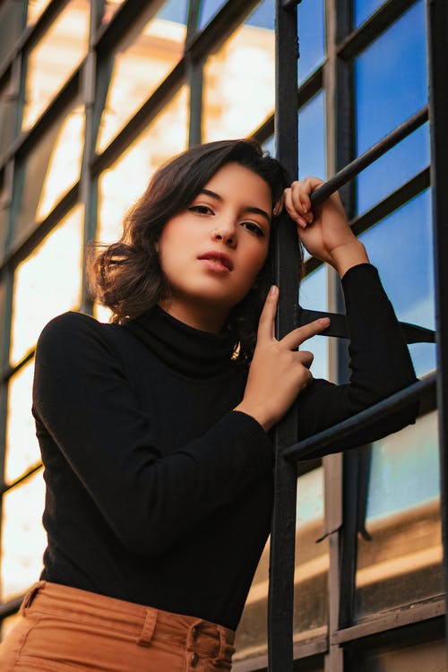 女人靠在屋顶通道梯子上的照片 · 免费素材图片