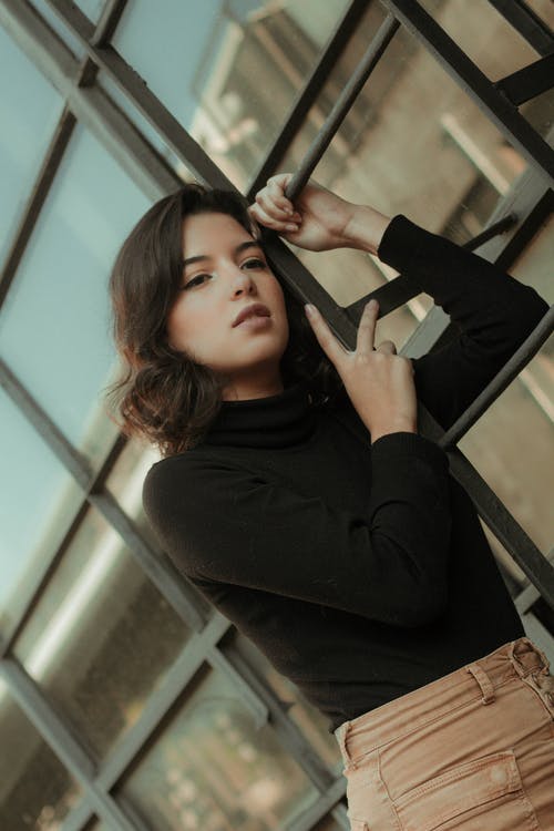 女人靠在屋顶通道梯子上的照片 · 免费素材图片