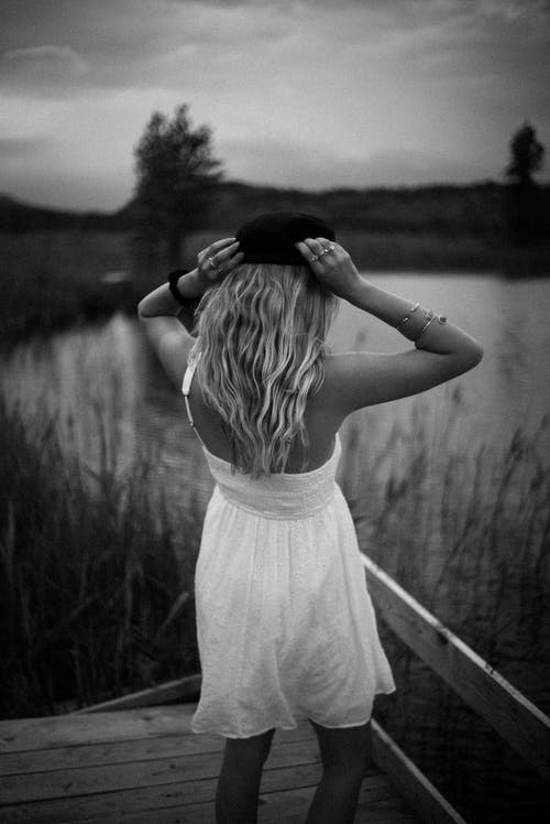 站在水体附近的女人的灰度照片 · 免费素材图片