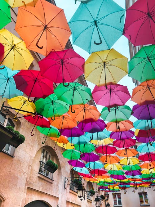 各种颜色的雨伞挂在建筑物附近的照片 · 免费素材图片