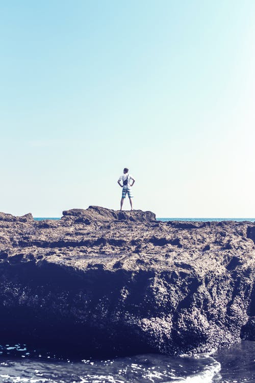 男子站在灰色的岩石上 · 免费素材图片