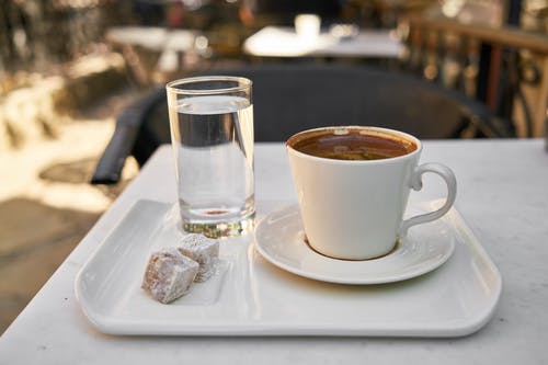 白色陶瓷咖啡杯和托盘上的水杯 · 免费素材图片