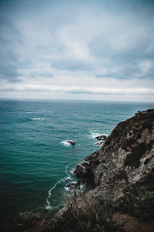 黑色和灰色悬崖向水体 · 免费素材图片