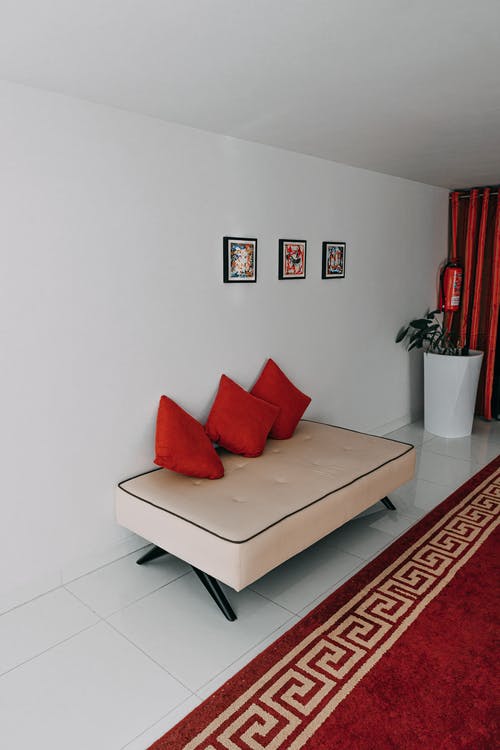 在房间里的白色沙发上的三个红扔枕头 · 免费素材图片