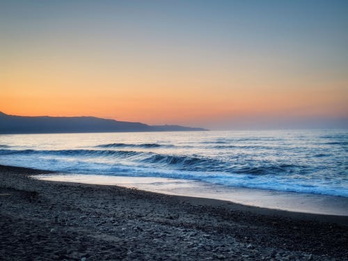 浪溅在黑沙海滩岸边 · 免费素材图片