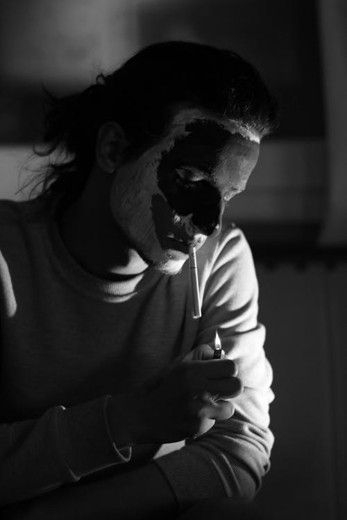 男子即将用打火机点燃香烟 · 免费素材图片