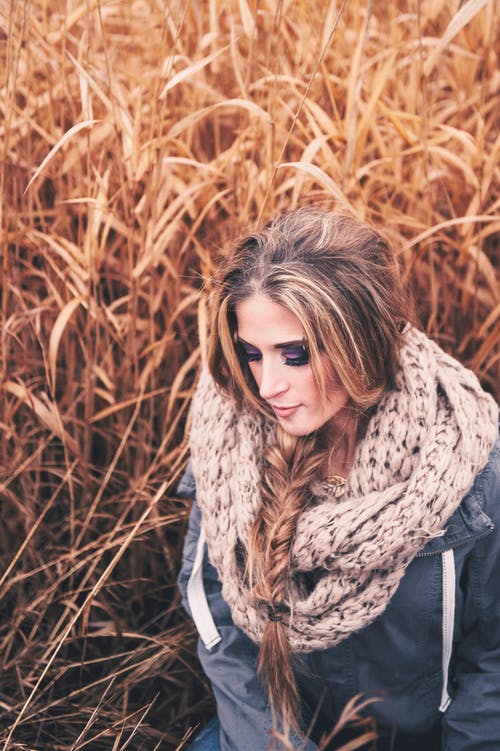 高大的棕色草构成的蓝色外套和针织的围巾的女人的选择性聚焦照片 · 免费素材图片