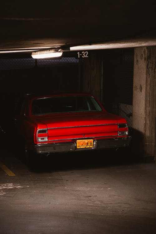 停在地下停车场的红色肌肉车的照片 · 免费素材图片