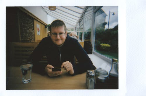 男子手持手机微笑的照片 · 免费素材图片