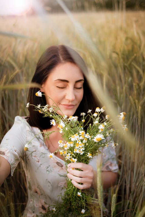 女人抱着白花的照片 · 免费素材图片