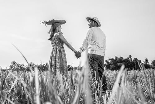 男人和女人在户外牵手的灰度照片 · 免费素材图片