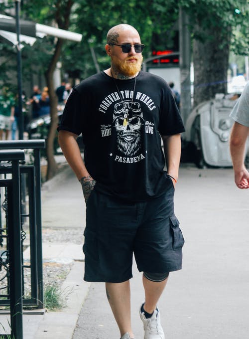 走在人行道上的纹身的秃头男人的照片 · 免费素材图片