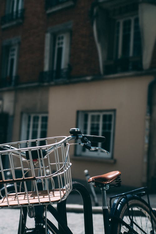 停放的城市自行车与建筑在背景中的特写照片 · 免费素材图片