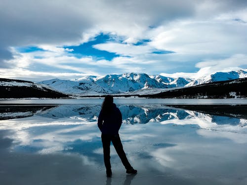 女人面对雪山的剪影照片 · 免费素材图片