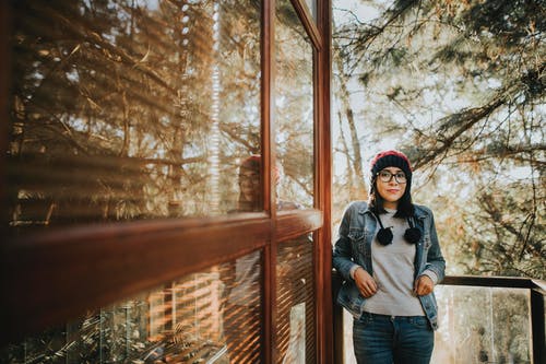 站在棕色全轻面板门旁边的女人 · 免费素材图片