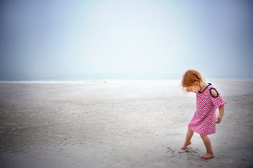 在白天的时候，在海边的沙滩上玩的女孩 · 免费素材图片