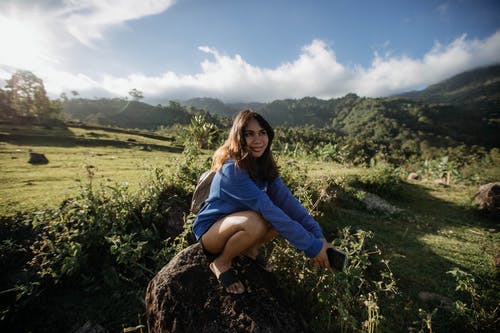 女人在草地附近的蓝色长袖衬衫的浅焦点照片 · 免费素材图片