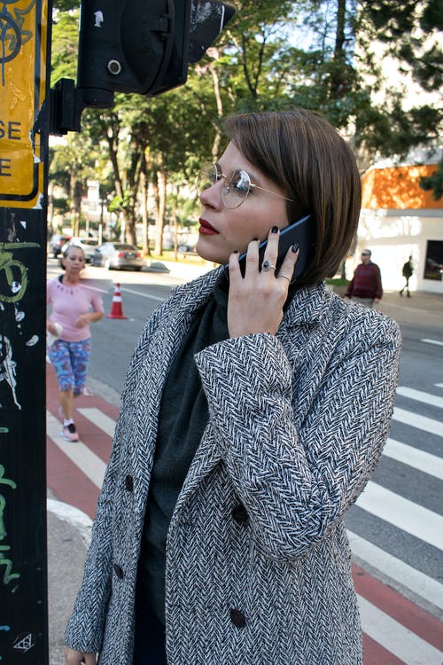 一个女人打电话给她的手机的女人的照片 · 免费素材图片
