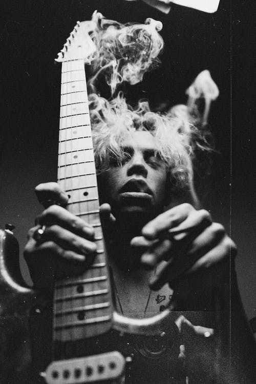 一个人抱着吉他的黑白摄影 · 免费素材图片