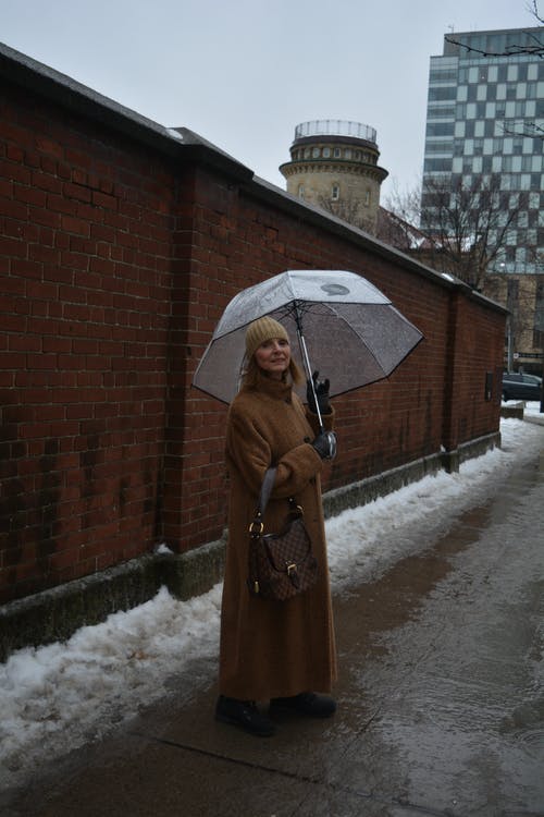 一个女人背着伞的照片 · 免费素材图片