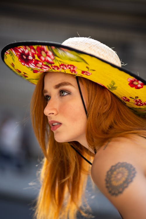 女人戴着太阳帽的特写照片 · 免费素材图片