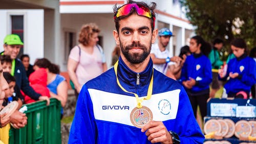 男子展示他的奖牌的照片 · 免费素材图片