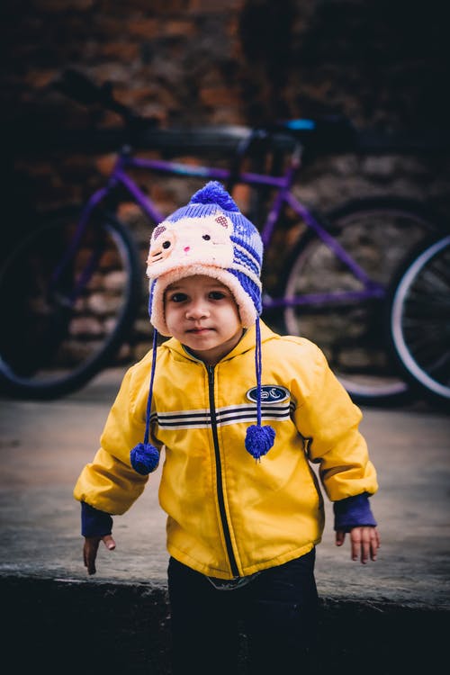 男孩站在自行车附近 · 免费素材图片
