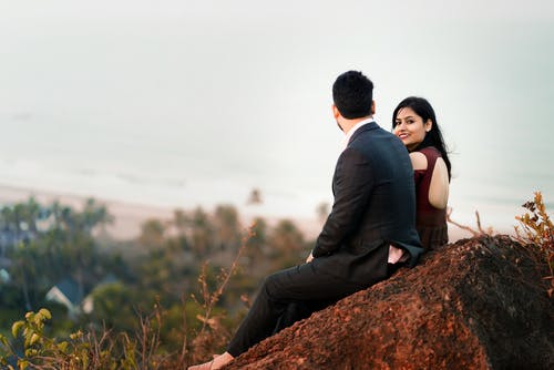 男人和女人坐在岩石上 · 免费素材图片