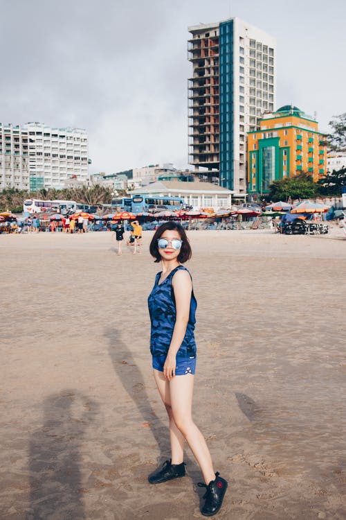 站在海滩上的女人的照片 · 免费素材图片