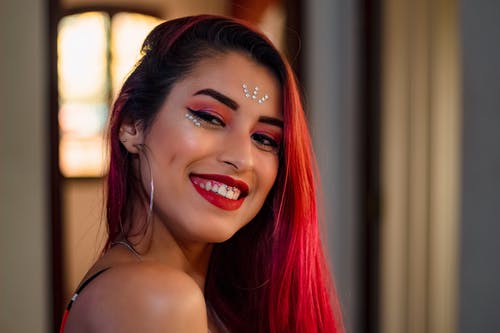 明亮的红色头发的微笑女人的画像 · 免费素材图片