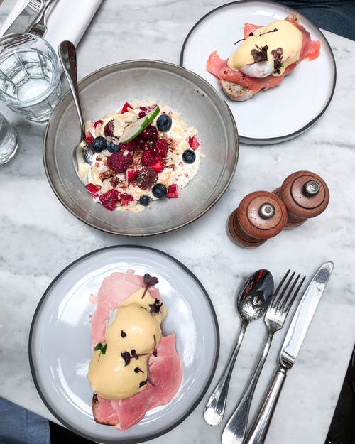 本尼迪克特鸡蛋在白色和黑色的陶瓷板上 · 免费素材图片