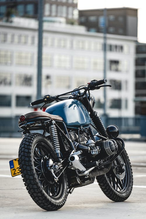 停放的蓝色和黑色咖啡馆赛车摩托车的选择性聚焦照片 · 免费素材图片