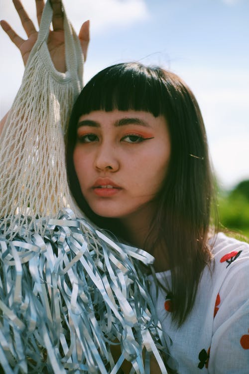 一个女人抱着灰色和米色的网的肖像照片 · 免费素材图片