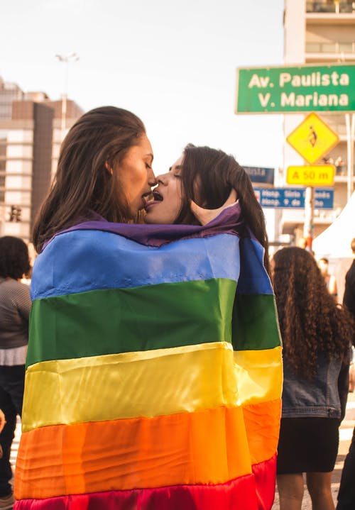 两个女人被包裹在彩虹旗时亲吻 · 免费素材图片